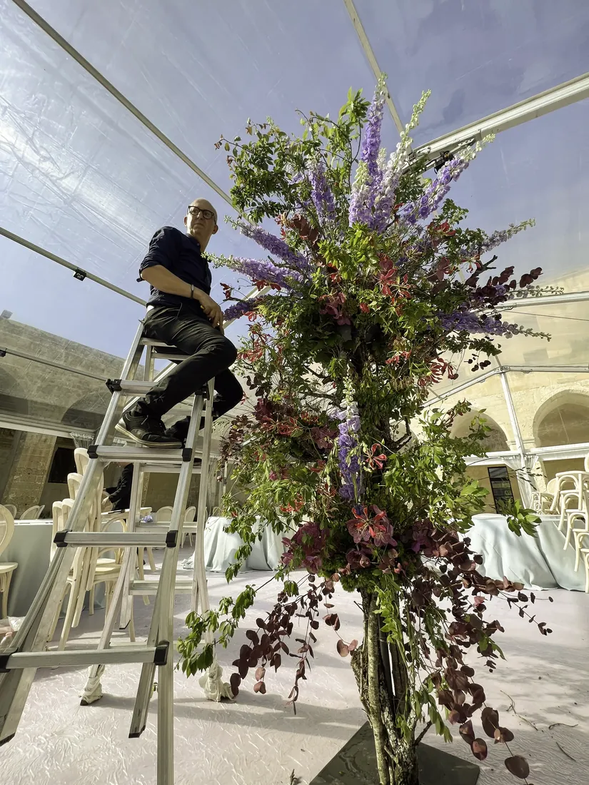 Montaggio di una composizione floreale monumentale nella tensostruttura del Chiostro dei Domenicani